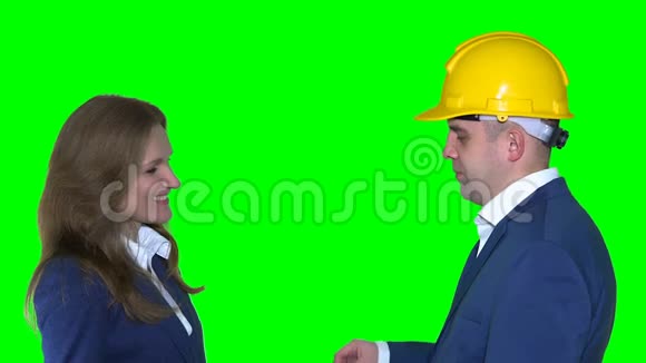 房地产经纪人戴头盔的男人给幸福的客户女人新的公寓钥匙视频的预览图