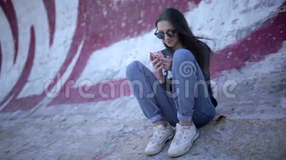 戴眼镜的年轻黑发女人用半管智能手机视频的预览图