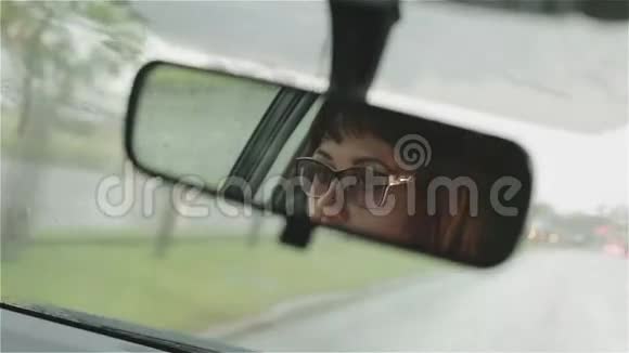 戴眼镜的女人在雨中开车视频的预览图