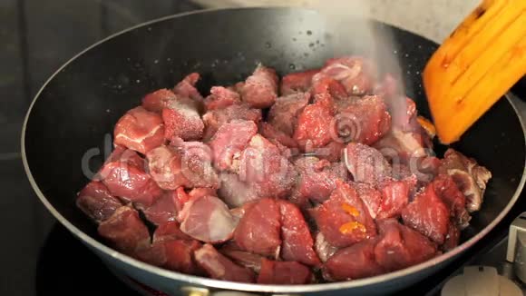 在煎锅里煎肉将肉放入煎锅中撒盐拌匀视频的预览图