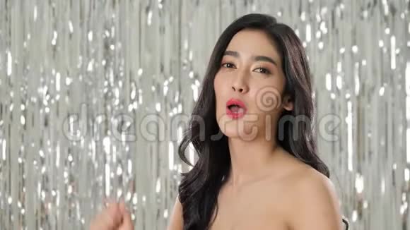 美丽的亚洲女人拿着一杯香槟在五彩纸屑中跳舞视频的预览图