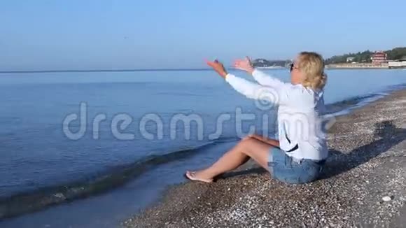 女人坐在阿佐夫海的海滩上视频的预览图