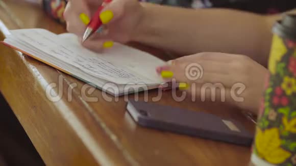 女人手在笔记本上写东西视频的预览图
