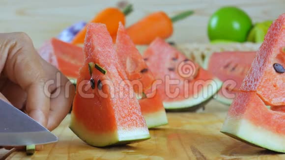 合拢双手微笑着面对一块成熟的西瓜放在木板上为夏天准备新鲜水果视频的预览图