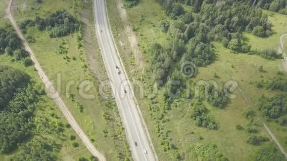 乡村道路环绕着郁郁葱葱的绿色自然剪辑森林乡村道路的俯视图农村公路交通视频的预览图