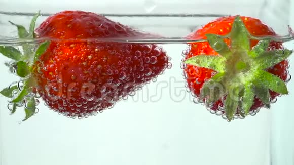 美味的红草莓在碳酸的清水中畅游视频的预览图