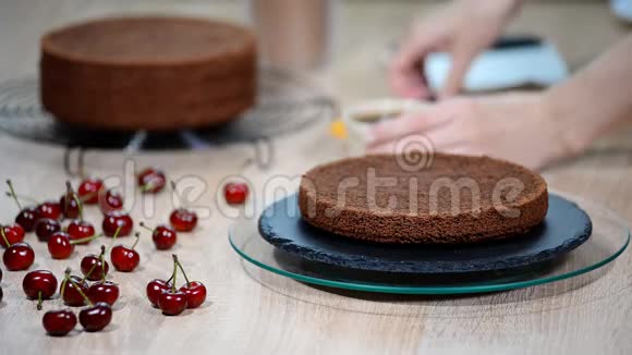 用樱桃准备巧克力蛋糕蛋糕用甜糖浆浸湿视频的预览图