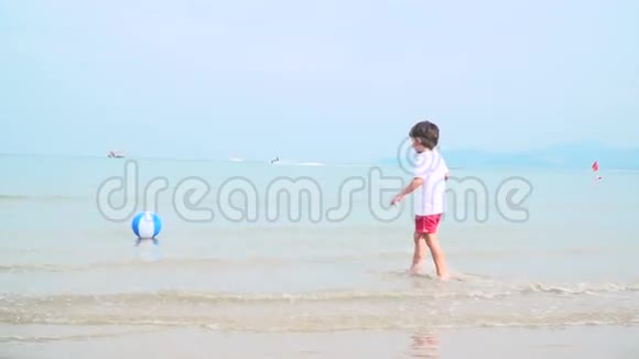小男孩正在泰国美丽的沙滩上玩五颜六色的水球视频的预览图