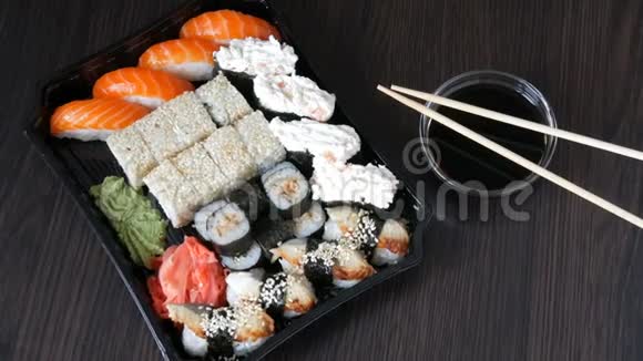 大型寿司套装有很多寿司卷肉卷黑吉里甘坎时尚寿司套在黑木桌旁边的大豆视频的预览图