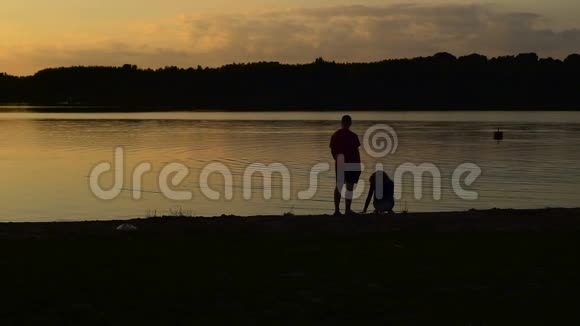 一个年轻的女人和一个男人正在湖边散步视频的预览图