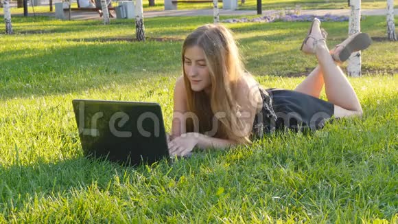 在外面草地上的笔记本电脑上的女人视频的预览图