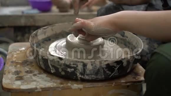 波特在一个车间里用手指在陶轮上做一个陶瓷碗视频的预览图