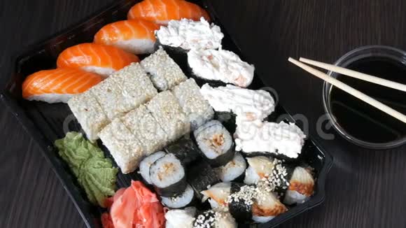 大型寿司套装有很多寿司卷肉卷黑吉里甘坎时尚寿司套在黑木桌旁边的大豆视频的预览图