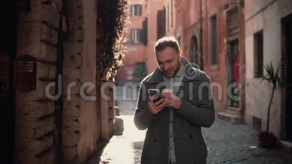 年轻有魅力的男人在城市里散步使用智能手机男性与朋友聊天喝咖啡视频的预览图