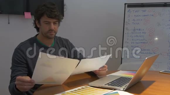 男人工作到很晚坐在办公室桌上手提电脑文件负面情绪视频的预览图