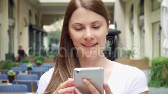在欧洲城市女人慢吞吞地走在街上女性通过手机与朋友聊天视频的预览图