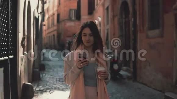 年轻迷人的女人在城市里散步使用智能手机女孩和朋友聊天喝咖啡视频的预览图