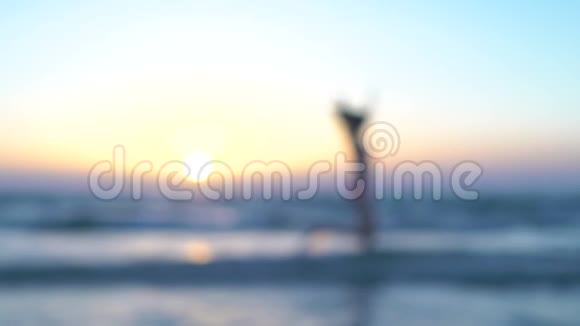 穿着粉红色泳衣的漂亮女人正在海滩上跑步晒太阳坐在海里或海洋里快乐的女孩奔向日落视频的预览图