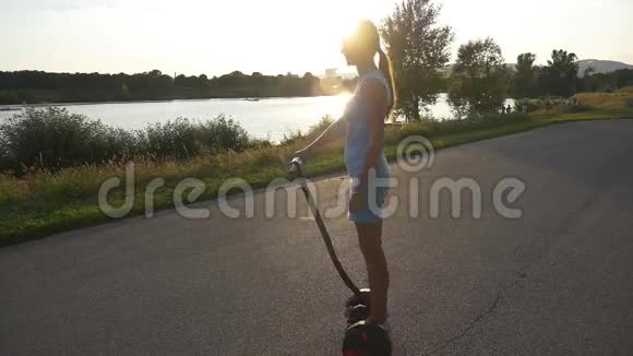 在塞格威的女人骑着车去日落视频的预览图