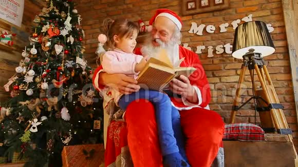 圣诞老人坐在椅子上抱着小女孩视频的预览图