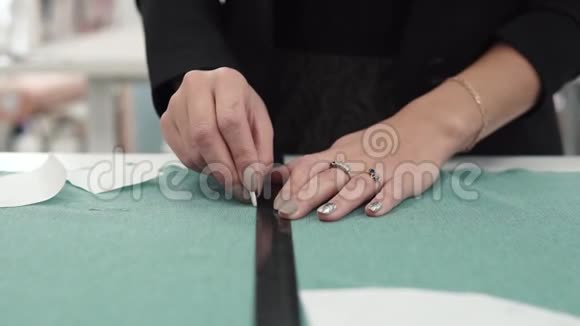 女人把图案带到布料上女性手特写那个女孩正在织物上画粉笔视频的预览图