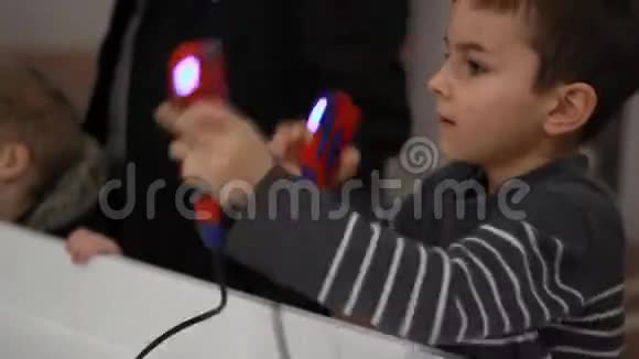 手里拿着游戏本的男孩拳击儿童遥控机器人视频的预览图