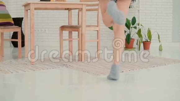 厨房里跳舞的美女微笑的女孩穿着睡衣在家享受早晨慢动作视频的预览图