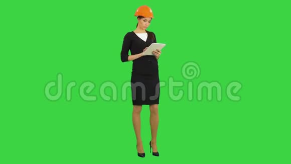 女建筑师在硬帽手持平板电脑和做检查的绿色屏幕铬键视频的预览图