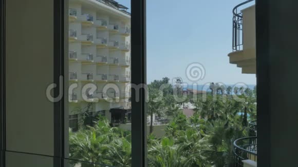 从酒店的窗户可以看到漂亮的海景棕榈树女孩从她的房间里拍了一张风景照视频的预览图