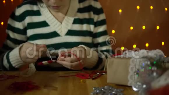 一位年轻女子在黄电灯旁边为一棵圣诞树做装饰视频的预览图