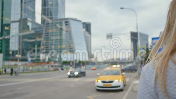 市中心的一个女孩乘出租车或路过的汽车视频的预览图