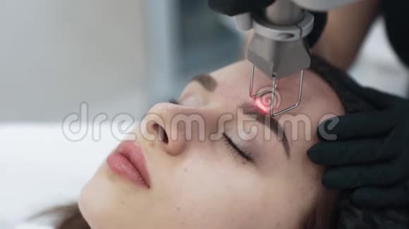 临床激光面部治疗中年轻女性面部特写慢动作视频的预览图
