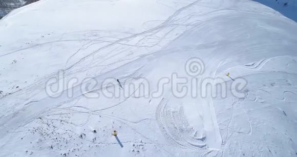 空中跟随滑雪者高山滑雪在冬季雪山滑雪场在晴天阿尔卑斯山脉之上视频的预览图