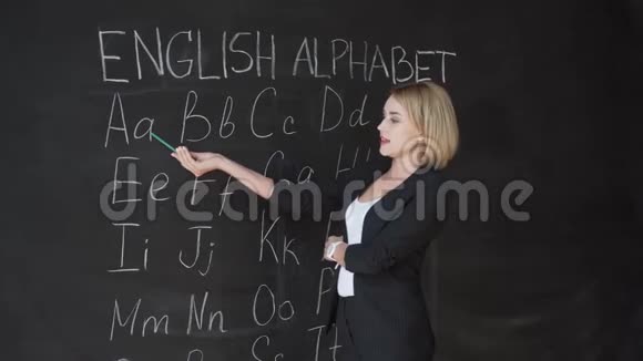 老师正在用粉笔在黑板上写字母表小学教育理念视频的预览图