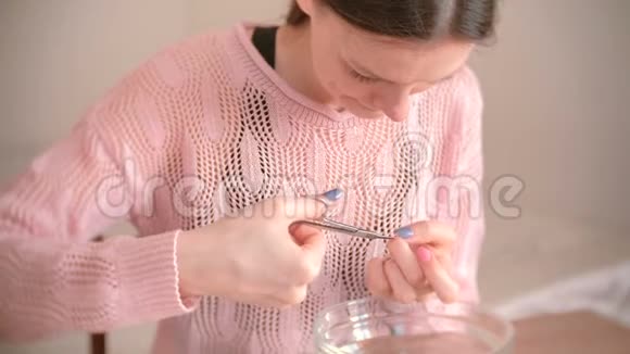 女人用剪刀和剪刀剪角质层自己修指甲桌子上的人造工具视频的预览图