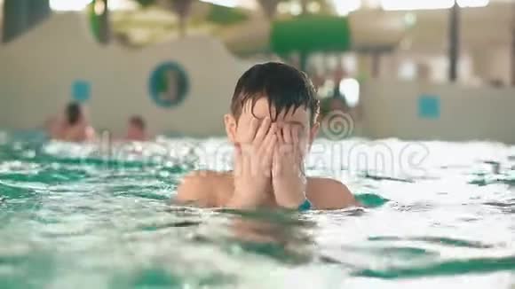 男孩少年在水中的公共室内游泳池水上公园视频的预览图