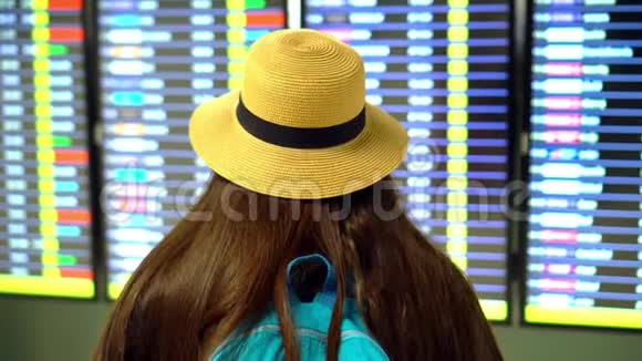 一个机器人那个长着一头深色长发戴着草帽的女孩检查飞机的登机情况看时间表的女人视频的预览图