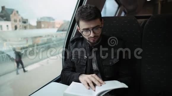 一个小男孩走在火车上看书戴眼镜的男孩4k视频的预览图