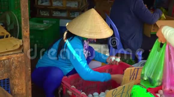 女人选择鸡蛋越南的市场市场上大量的白蛋鸡蛋分类越南视频的预览图
