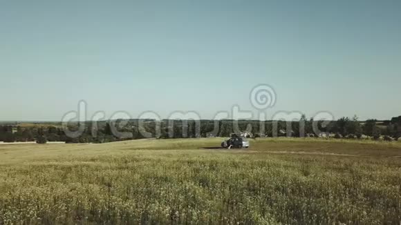空中无人驾驶飞机飞过田野里的汽车夏天阳光明媚的日子视频的预览图