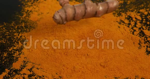 姜黄姜黄根落在姜黄粉上印度香料慢运动视频的预览图