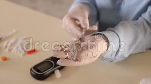戴着医用手套的妇女正在用胰岛素注射器取出胰岛素视频的预览图