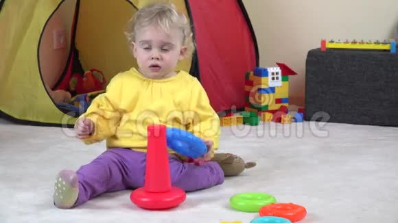 卷发的女婴玩五颜六色的儿童金字塔视频的预览图