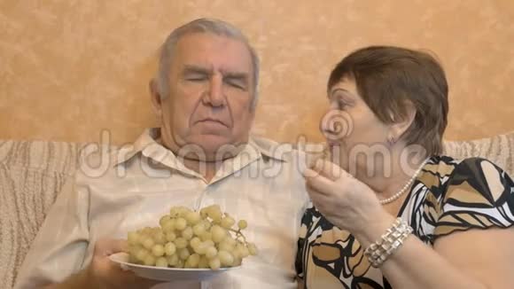 老夫妇吃葡萄浆果他们互相喂养快乐时光视频的预览图