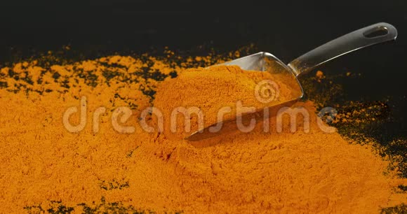 姜黄姜黄根落在姜黄粉上印度香料慢运动视频的预览图
