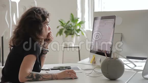 在电脑工作的女雇员坐在办公室漂亮的深色头发视频的预览图