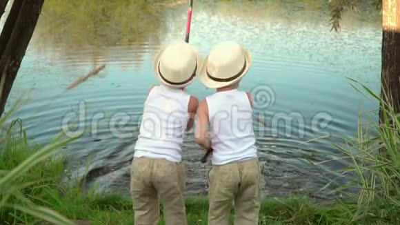 孩子们在池塘边钓鱼孩子们站在湖边手里拿着棍子视频的预览图