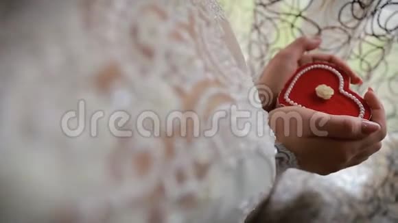 美丽的女人x27手握心形订婚戒指盒新娘手里拿着一个心形礼盒视频的预览图