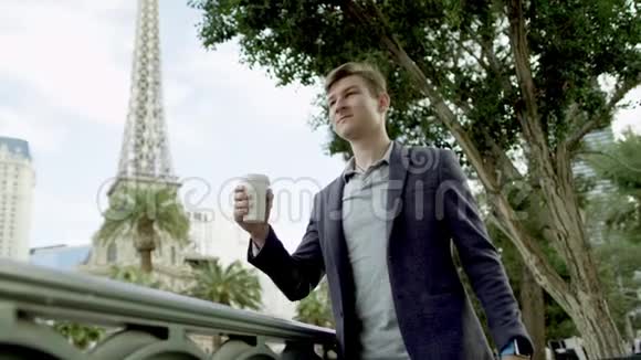 年轻人站在一条街上喝咖啡背景是埃菲尔铁塔视频的预览图