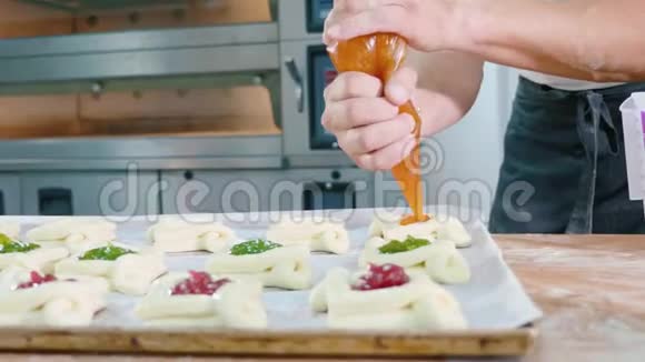 专业面包师在放入烤箱前将果酱加入甜烤炉上视频的预览图